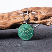 Load image into Gallery viewer, Rear view of the Orgonite pendant necklace made with green peridot crystals showing gold foil shavings.