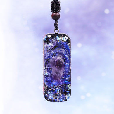 An orgonite pendant necklace with a single Amethyst crystal in the center and a marbled design that appears like a surrounding galaxy.