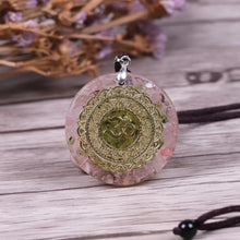 Load image into Gallery viewer, A soft pink orgonite necklace featuring an Olivine crystal center surrounded by warm Rose Quartz. crystals. Features a front-facing 'AUM' copper energy patch.