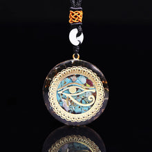 Load image into Gallery viewer, Handmade orgonite necklace with turquoise and obsidian crystals on a dark background, showcasing the pendant’s vibrant blue and black hues with embedded metal shavings.