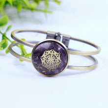 Load image into Gallery viewer, An orgonite bracelet with a brushed copper bangle. Amethyst stones and gold foil shavings surround a sacred Sri Yantra energy patch.