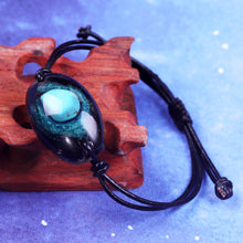 Load image into Gallery viewer, An orgonite bracelet that resembles a galaxy, with Obsidian surrounding a single Turquoise stone.