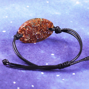 An orgonite bracelet with seven types of crystal stone, gold foil shavings, and a Sri Yantra energy patch.