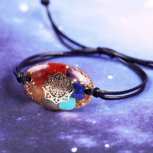 An orgonite bracelet with seven types of crystal stone, gold foil shavings, and a Sri Yantra energy patch.