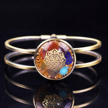 Load image into Gallery viewer, Orgonite bracelet with a brushed copper bangle. Seven stones and gold foil shavings surround a sacred Sri Yantra energy patch.