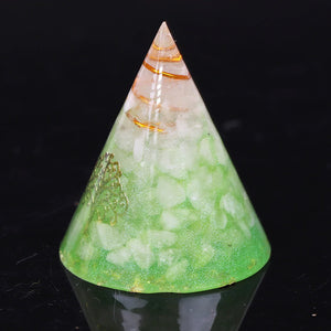 An orgonite cone with a quartz crystal in a copper energy coil. Features a copper foil Tree of Life energy patch and gold foil shavings.