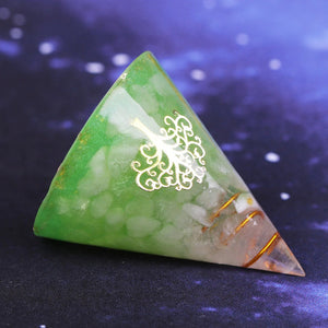 An orgonite cone with a quartz crystal in a copper energy coil. Features a copper foil Tree of Life energy patch and gold foil shavings.