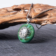 Load image into Gallery viewer, Orgonite pendant necklace made with green peridot crystals and a silver chain.