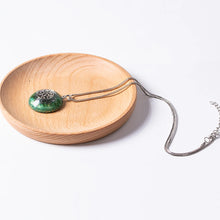 Load image into Gallery viewer, Orgonite pendant necklace made with green peridot crystals and a silver chain.