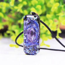 Load image into Gallery viewer, An orgonite pendant necklace with a single Amethyst crystal in the center and a marbled design that appears like a surrounding galaxy.