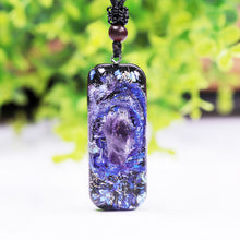 Load image into Gallery viewer, An orgonite pendant necklace with a single Amethyst crystal in the center and a marbled design that appears like a surrounding galaxy.