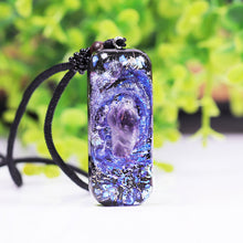 Load image into Gallery viewer, An orgonite pendant necklace with a single Amethyst crystal in the center and a marbled design that appears like a surrounding galaxy.