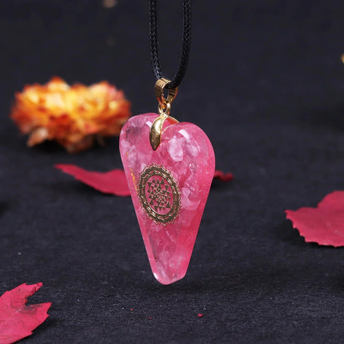 A heart shaped orgonite pendant necklace with Rose Quartz crystals and a Sri Yantra copper energy patch.