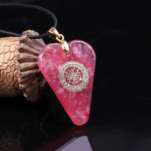 A heart shaped orgonite pendant necklace with Rose Quartz crystals and a Sri Yantra copper energy patch.