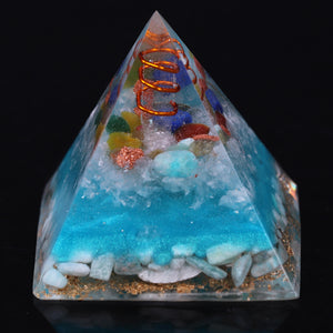 Sky blue orgonite pyramid with seven crystal stones. Features a quartz and copper energy coil, with a copper Tree of Life energy patch.