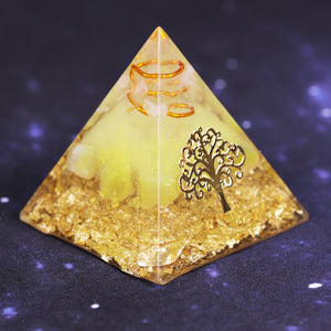 An orgonite pyramid with Quartz and Yellow Agate crystals. Features quartz in a copper energy coil, a Tree of Life energy patch and gold foil shavings.