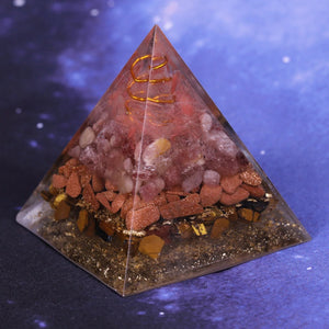 An orgonite pyramid with Strawberry Quartz, Tiger's Eye and Goldstone crystals. Features a Quartz crystal set in a Copper Energy Coil and Flower of Life copper energy patch.