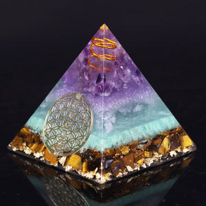 Orgonite pyramid with Tiger's Eye, Amethyst and Fluorite crystals. Includes a quartz crystal in a copper energy coil, gold foil shavings and a sacred Flower of Life energy patch.