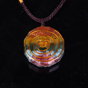 Orgonite pendant necklace with six types of crystal, silver foil shavings and a spiral copper energy coil.