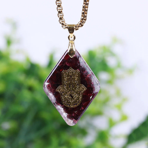 Orgonite pendant necklace with garden stones and a copper Hamsa energy patch.