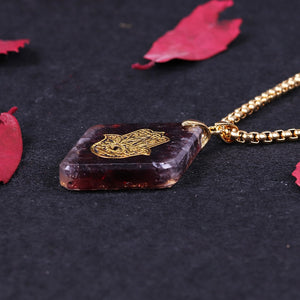 Orgonite pendant necklace with garden stones and a copper Hamsa energy patch.