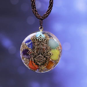 Orgonite pendant necklace with seven stones and a copper Hamsa energy patch.