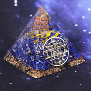 An orgonite pyramid with Lapis Lazuli & Quartz crystals. Includes a Sri Yantra and Aum copper energy patch.