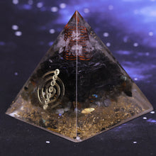 Load image into Gallery viewer, Orgonite pyramid with obsidian, labradorite and quartz crystals. Features a seven chakra copper energy patch and gold foil shavings.