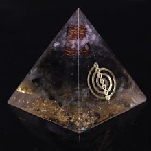 Load image into Gallery viewer, Orgonite pyramid with obsidian, labradorite and quartz crystals. Features a seven chakra copper energy patch and gold foil shavings.