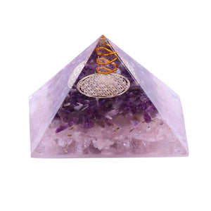 An orgonite pyramid containing natural Amethyst and Rose Quartz crystals. The top layer has an orgone energy copper coil on top of a copper energy patch.